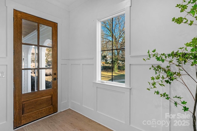 entryway featuring a decorative wall and light wood finished floors