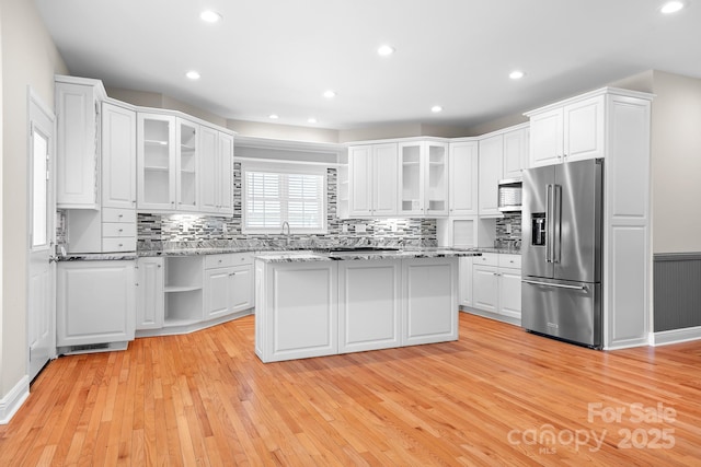 126 Emerald Dr, Mooresville, NC 28117 - kitchen with light wood-type flooring, glass insert cabinets, white cabinetry, backsplash, and stainless steel appliances