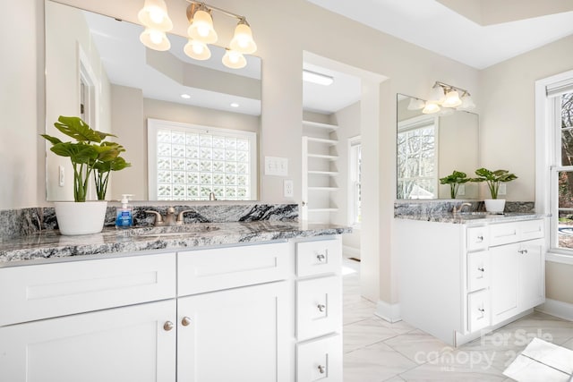 126 Emerald Dr, Mooresville, NC 28117 - full bathroom featuring two vanities, marble finish floor, an inviting chandelier, and baseboards