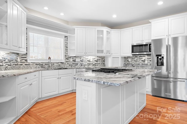126 Emerald Dr, Mooresville, NC 28117 - kitchen with open shelves, a sink, light wood-type flooring, white cabinetry, and stainless steel appliances