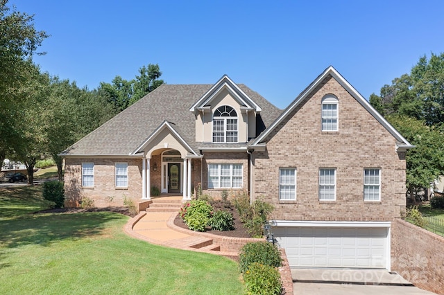 126 Emerald Dr, Mooresville, NC 28117 - view of front facade with concrete driveway, a front lawn, a garage, brick siding, and roof with shingles