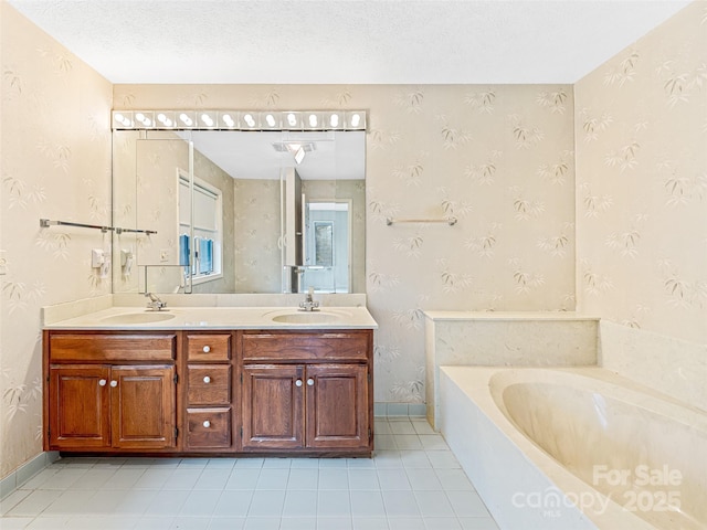 bathroom featuring a textured ceiling, a bathtub, and vanity