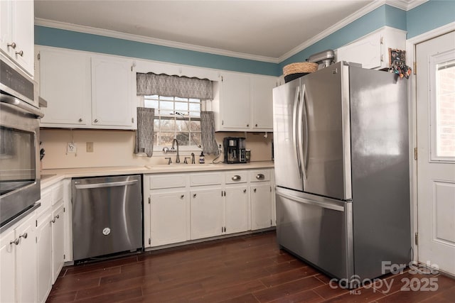 kitchen featuring crown molding, stainless steel appliances, light countertops, white cabinets, and a sink