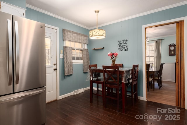 dining room with visible vents, ornamental molding, and dark wood-type flooring