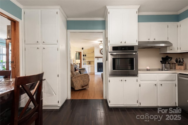 kitchen with stainless steel appliances, light countertops, white cabinetry, and under cabinet range hood