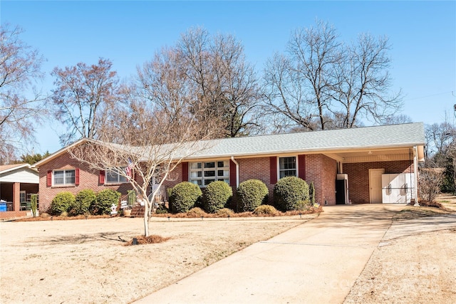 single story home with concrete driveway, brick siding, and an attached carport