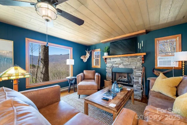 living room with a ceiling fan, plenty of natural light, wood finished floors, and baseboard heating