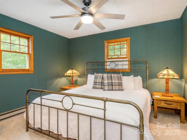 bedroom with carpet, baseboard heating, multiple windows, and ceiling fan