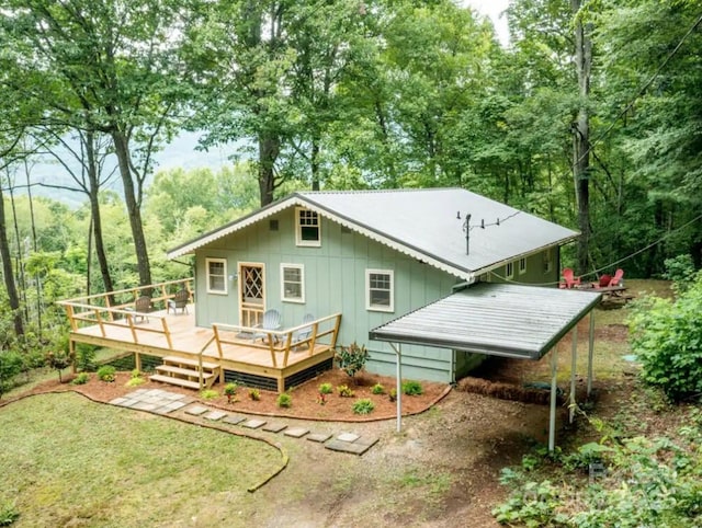rear view of property with board and batten siding and a wooden deck