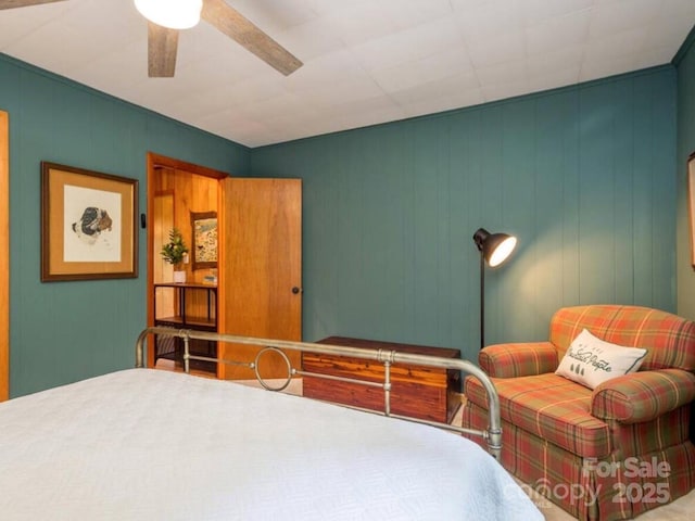 bedroom featuring a decorative wall and ceiling fan