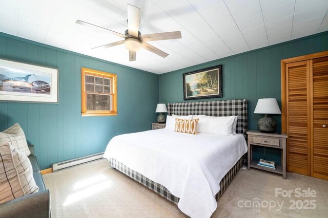 carpeted bedroom featuring a baseboard radiator, a closet, and ceiling fan