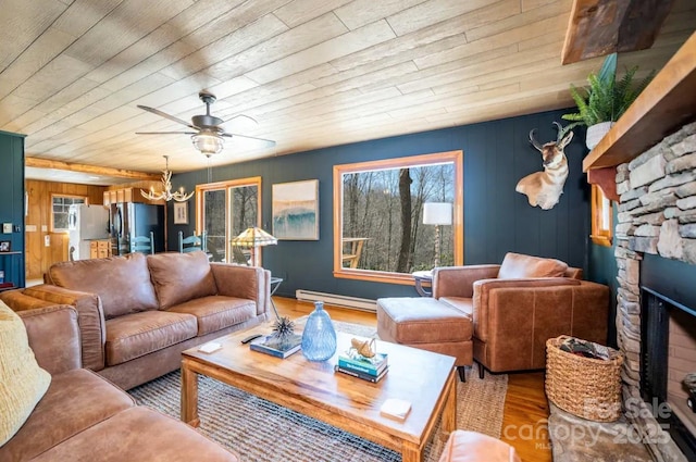 living room with a baseboard radiator, a wealth of natural light, wood finished floors, and wood ceiling