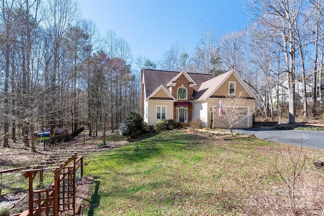 traditional home featuring aphalt driveway and a front lawn