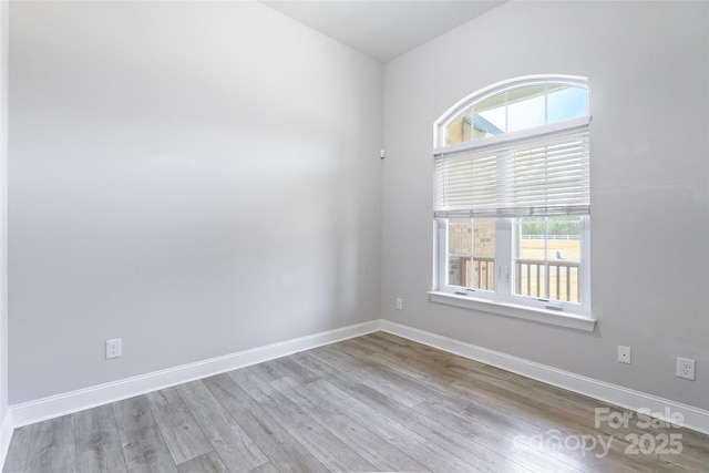 unfurnished room with baseboards and light wood-style floors