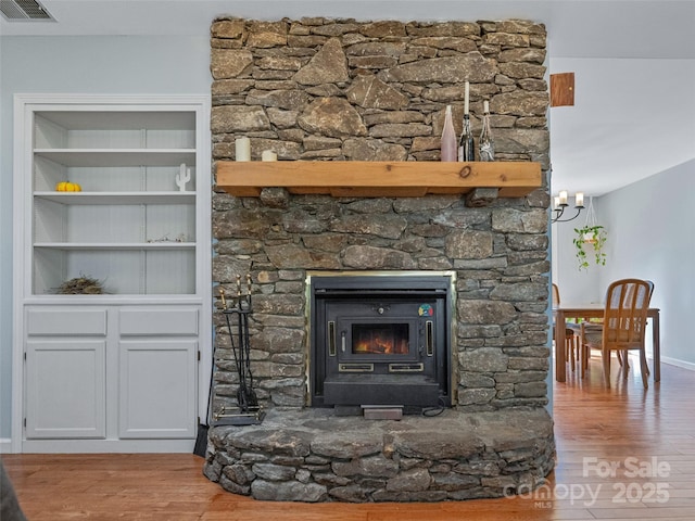 room details featuring built in shelves, wood finished floors, visible vents, and baseboards