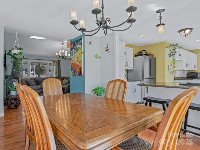 dining space with a chandelier and light wood-style floors