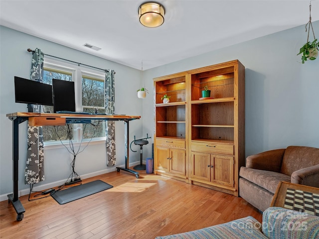 office area featuring light wood-style flooring, visible vents, and baseboards