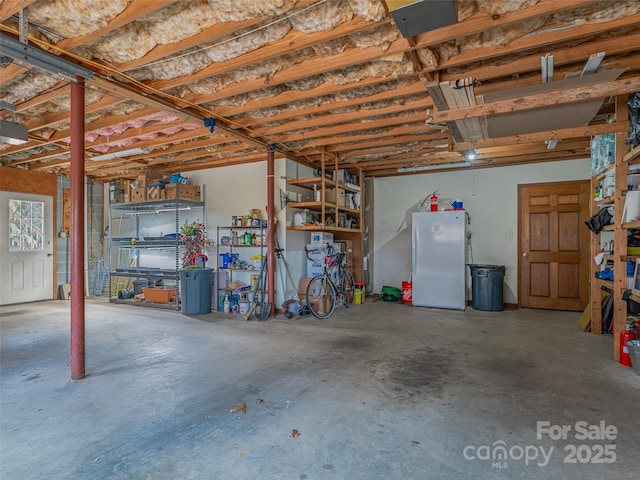 garage featuring a garage door opener and freestanding refrigerator