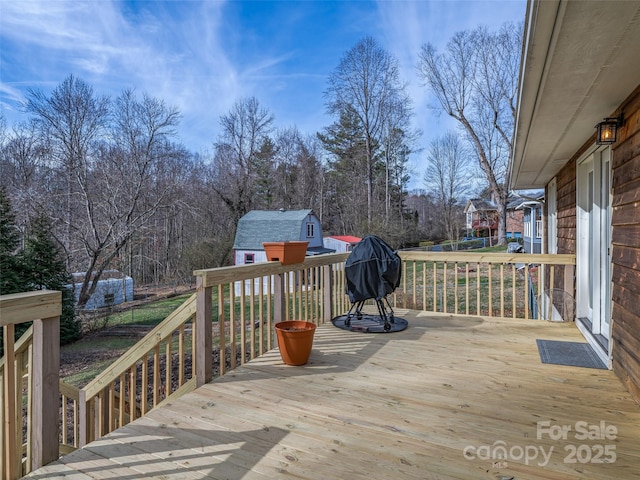 deck with a storage unit and an outbuilding