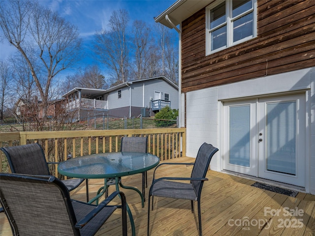 wooden deck with french doors, fence, and outdoor dining area