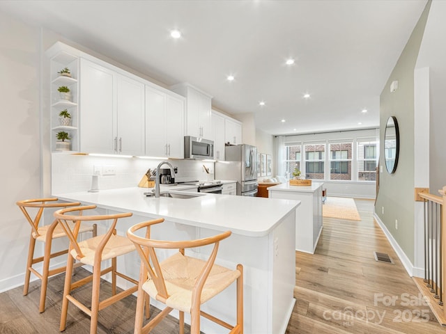 4010 Citra Ln, Charlotte, NC 28217 - kitchen featuring a sink, stainless steel appliances, a center island, backsplash, and light countertops