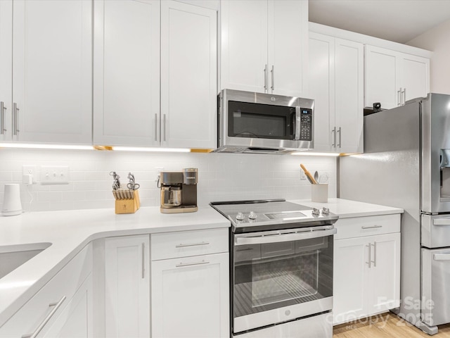 4010 Citra Ln, Charlotte, NC 28217 - kitchen featuring stainless steel appliances, white cabinetry, backsplash, and light countertops