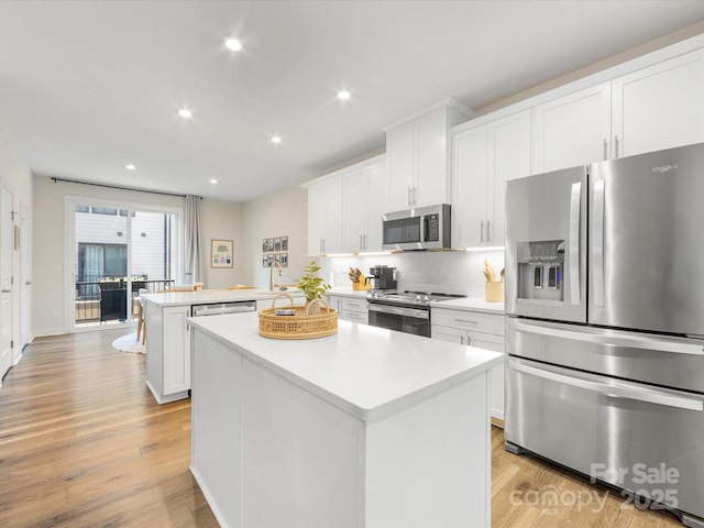 4010 Citra Ln, Charlotte, NC 28217 - kitchen featuring stainless steel appliances, a peninsula, a center island, light countertops, and white cabinets
