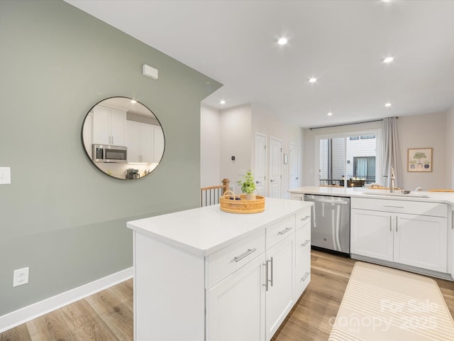 4010 Citra Ln, Charlotte, NC 28217 - kitchen with stainless steel appliances, a sink, a kitchen island, light wood-style floors, and recessed lighting