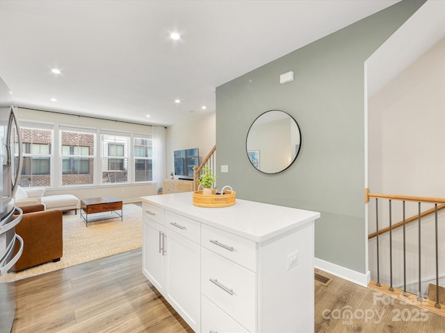 4010 Citra Ln, Charlotte, NC 28217 - kitchen featuring light wood-style floors, white cabinetry, recessed lighting, open floor plan, and a center island