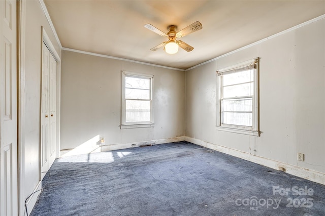 unfurnished bedroom featuring dark carpet, ceiling fan, and ornamental molding