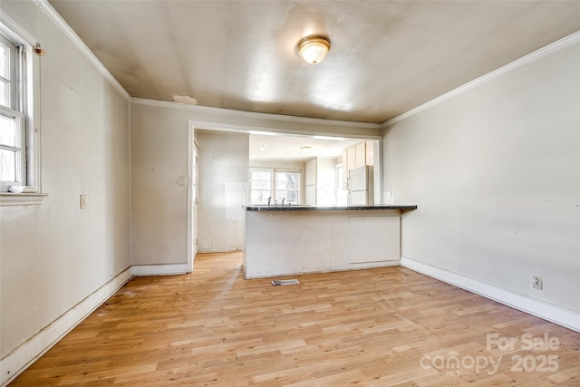 unfurnished living room with light wood-type flooring and crown molding