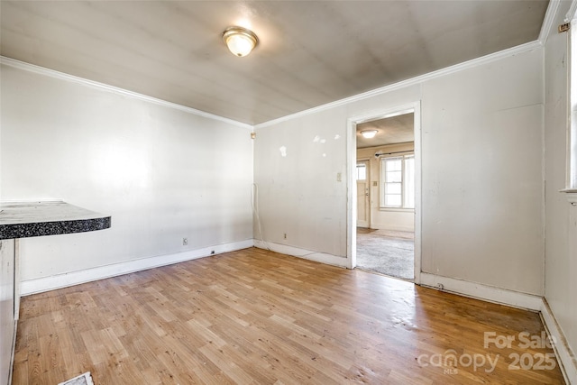 unfurnished dining area with ornamental molding and light wood-type flooring