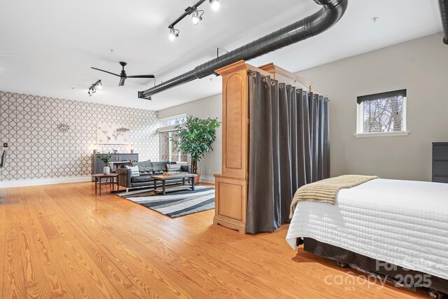 bedroom with track lighting and light wood-type flooring