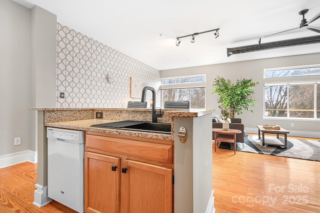 kitchen featuring white dishwasher, plenty of natural light, sink, and light hardwood / wood-style floors