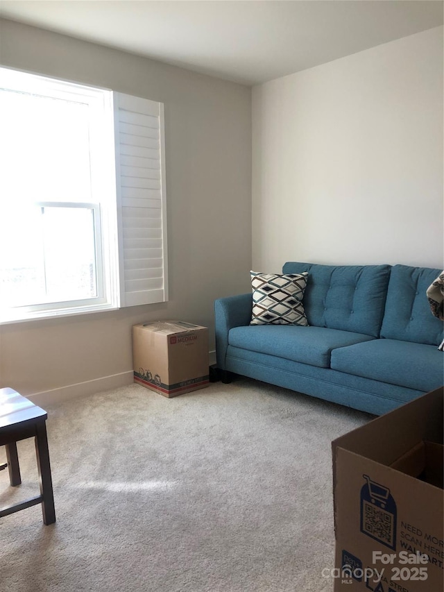 carpeted living room with baseboards