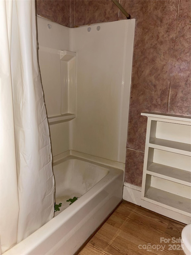 bathroom with curtained shower and wood finished floors