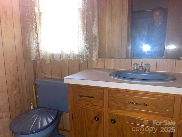 bathroom featuring wooden walls and vanity