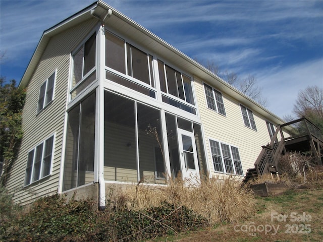 view of side of home featuring a sunroom