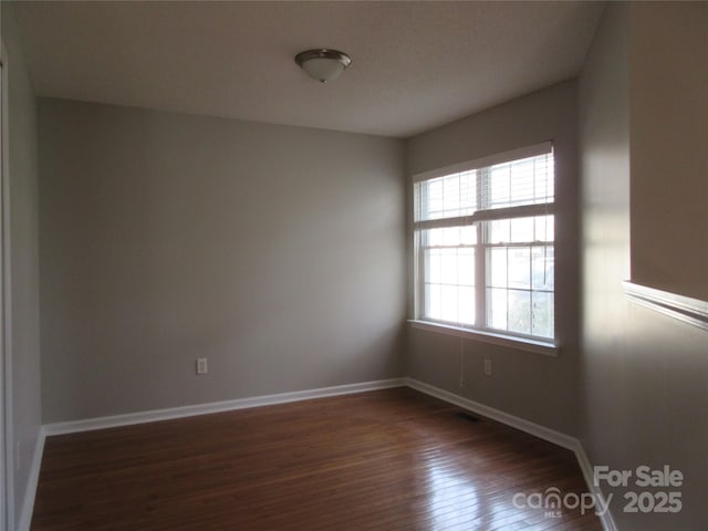 spare room with dark hardwood / wood-style floors