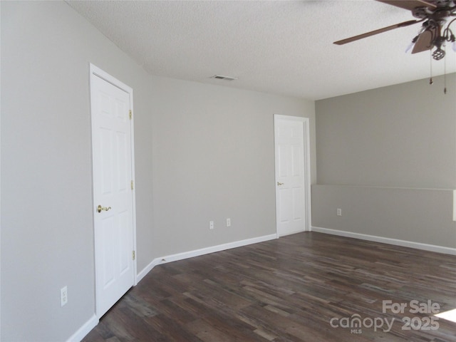 unfurnished room with ceiling fan, dark wood-type flooring, and a textured ceiling