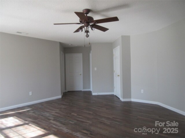 spare room with ceiling fan and dark wood-type flooring