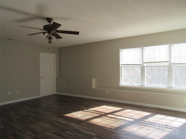 spare room featuring ceiling fan, dark wood-type flooring, and a textured ceiling