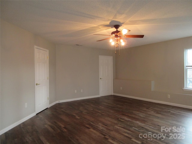 spare room featuring a textured ceiling, dark wood-type flooring, and ceiling fan