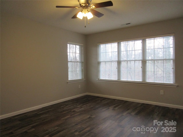 empty room with ceiling fan and dark hardwood / wood-style floors