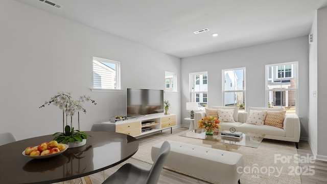 living area with light wood-type flooring, visible vents, baseboards, and recessed lighting