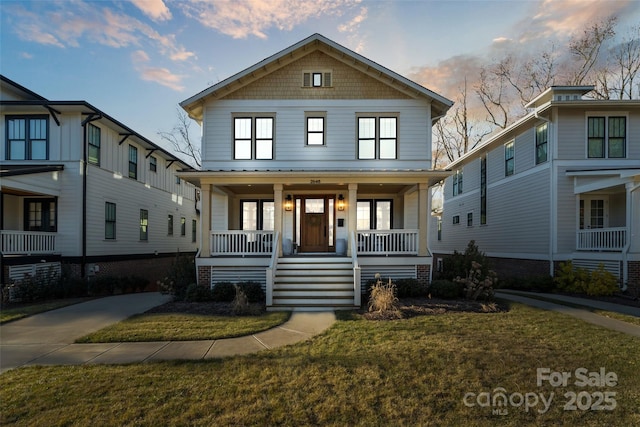 traditional style home featuring covered porch and a front yard