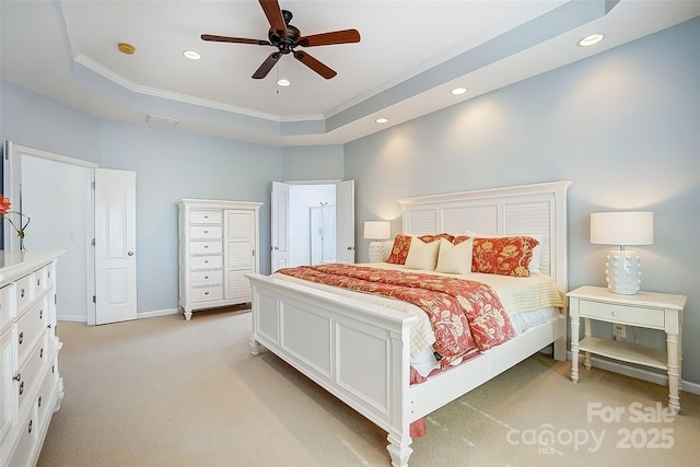 bedroom with light colored carpet, ceiling fan, a tray ceiling, crown molding, and recessed lighting