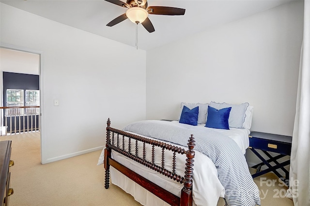 bedroom featuring a ceiling fan, light carpet, and baseboards