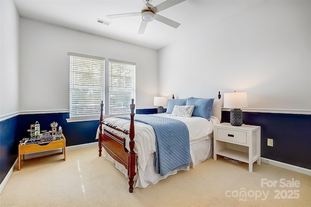 carpeted bedroom featuring a ceiling fan, visible vents, and baseboards