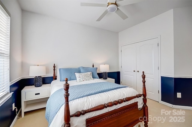 carpeted bedroom featuring a closet, multiple windows, and ceiling fan